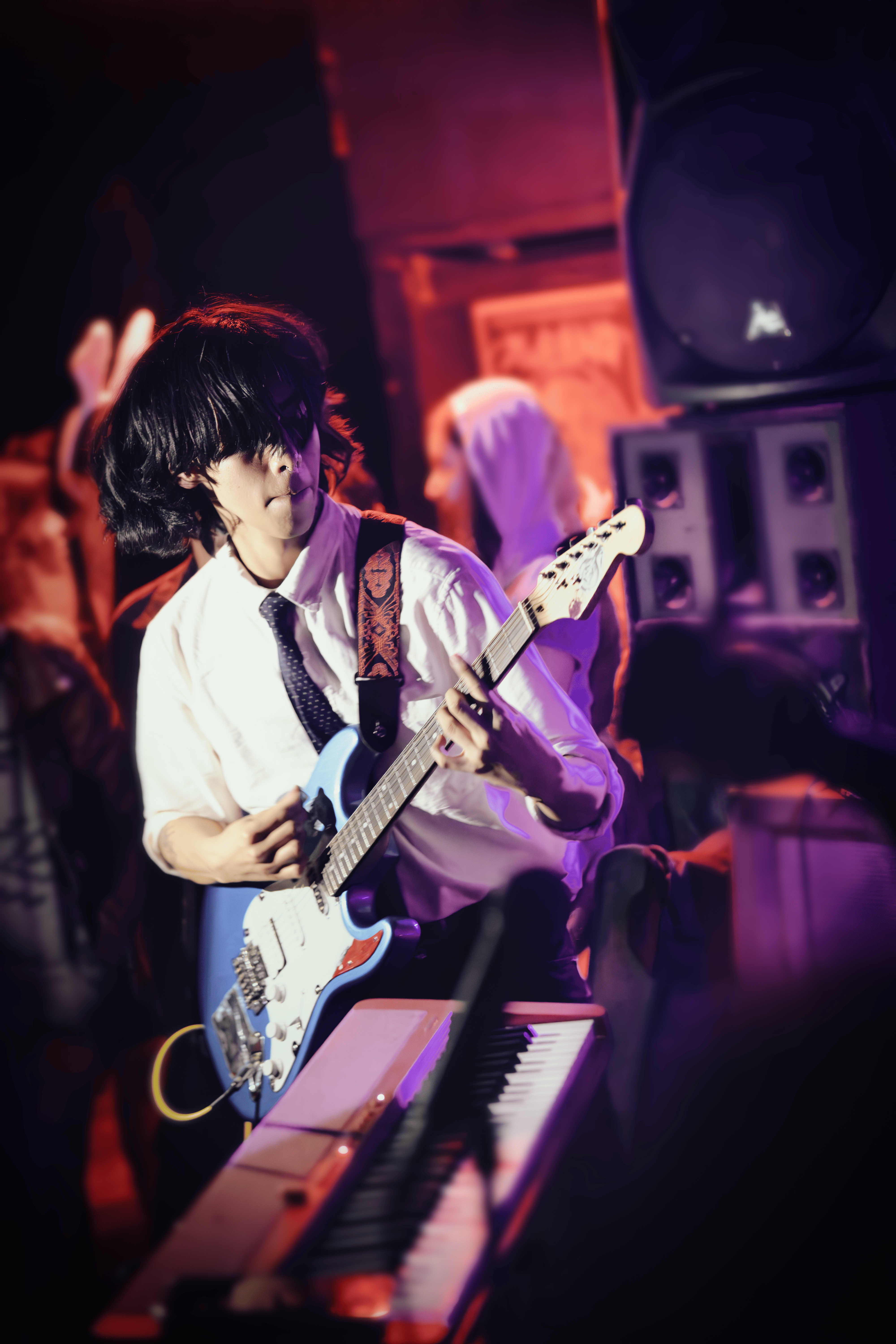 Guitarrista joven con corbata tocando con intensidad