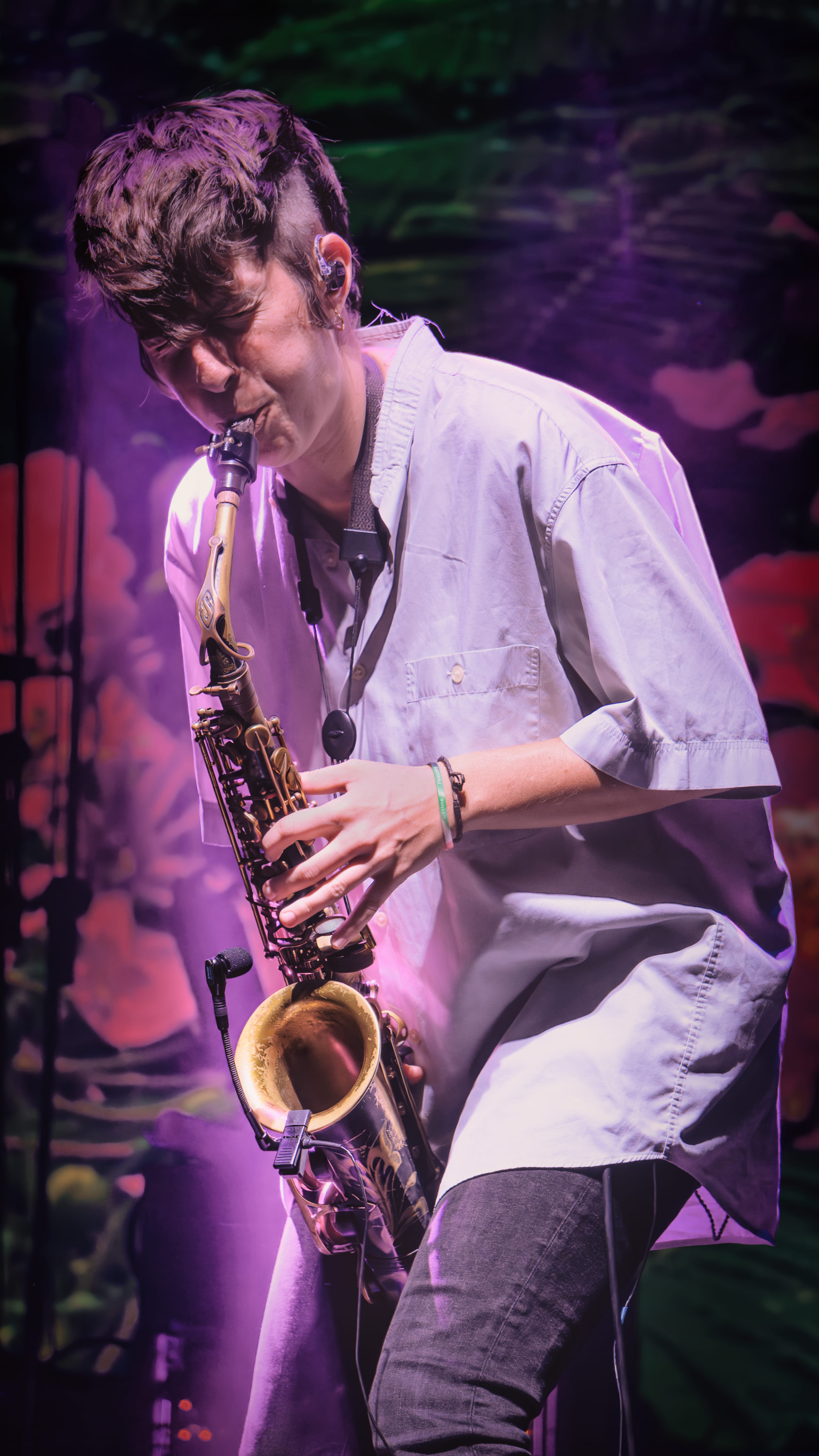 Joven saxofonista en escenario con luces moradas